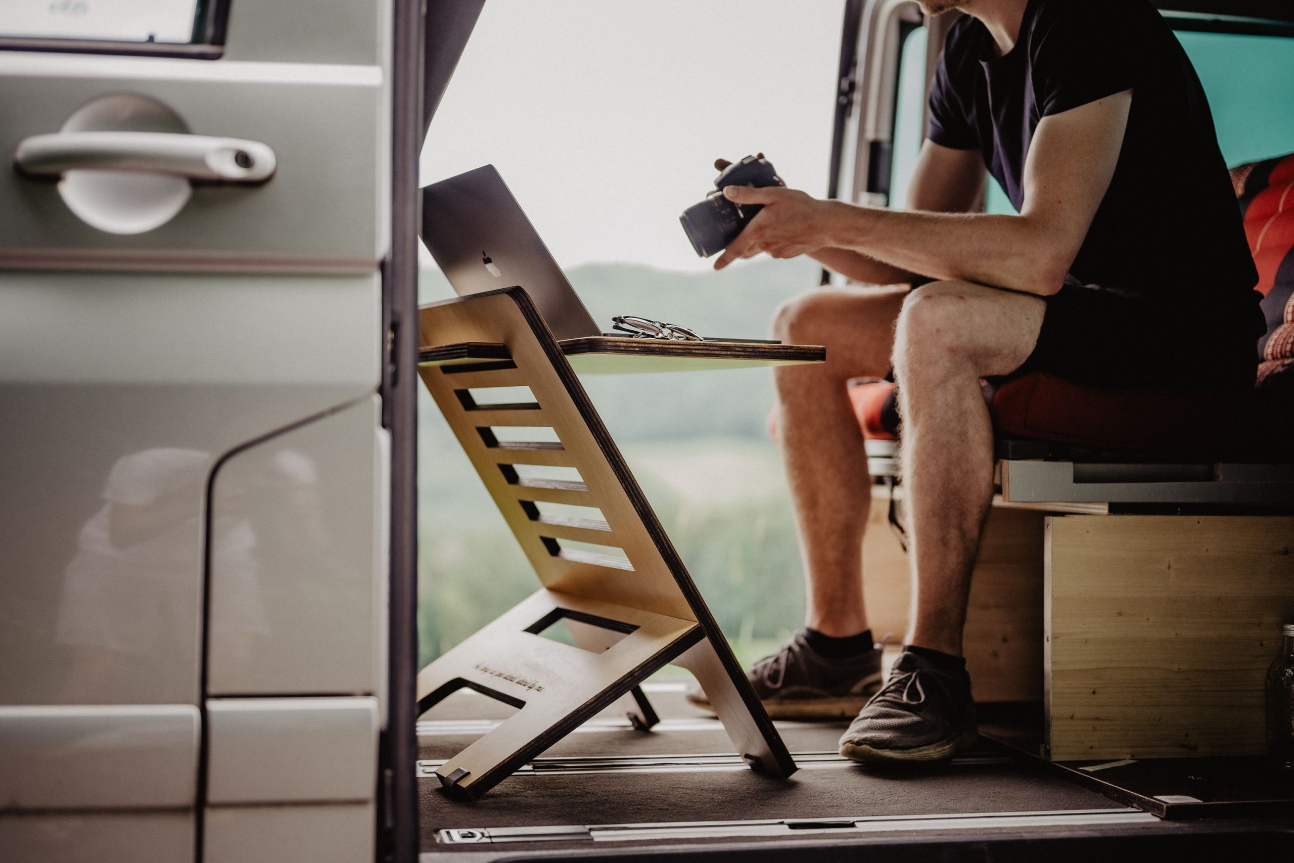 Homme travaillant en remote dans van avec bureau portable