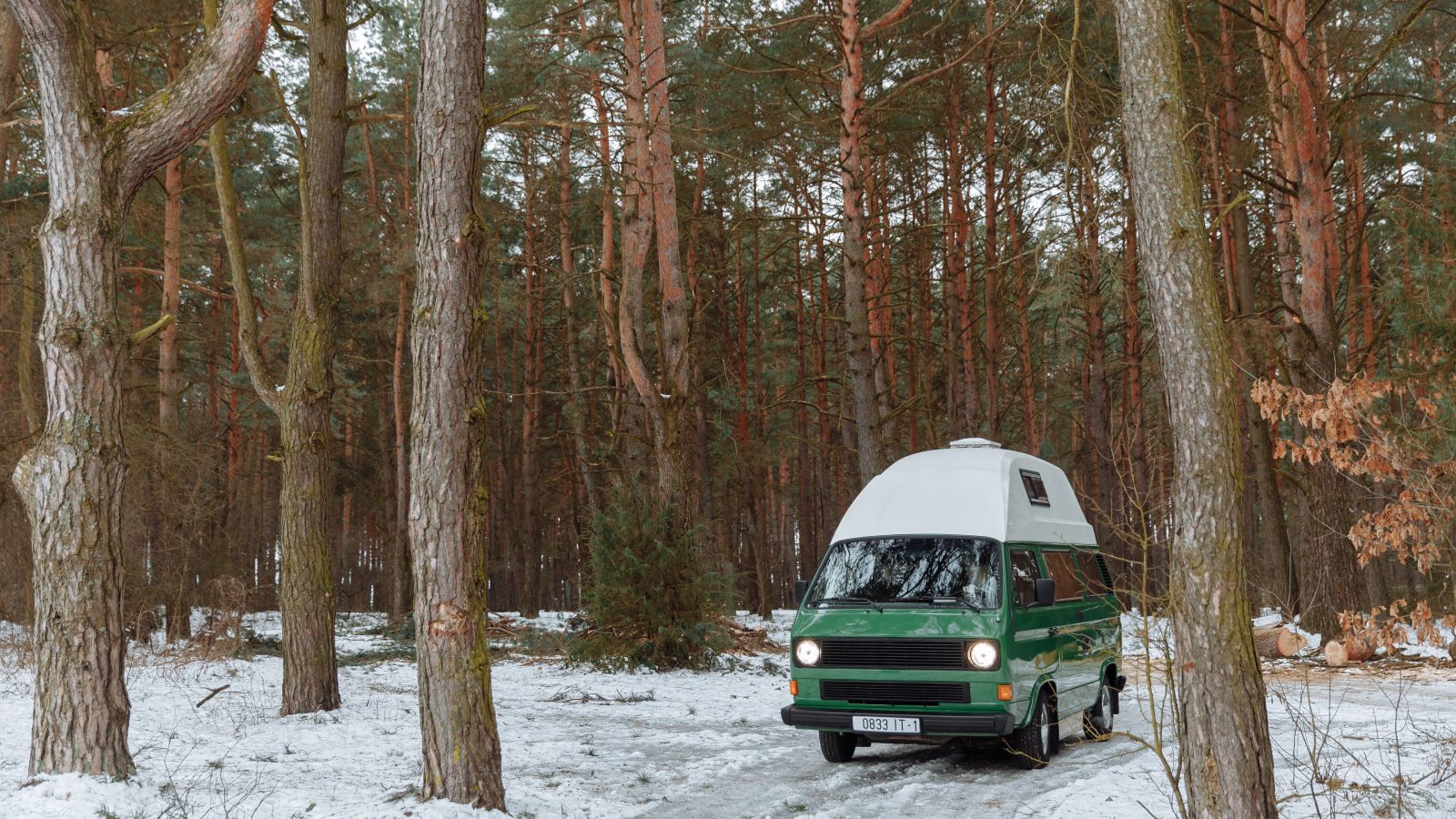Ancien camping-car enneigé en forêt hivernale