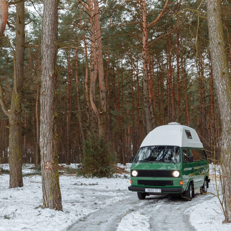 Ancien camping-car enneigé en forêt hivernale