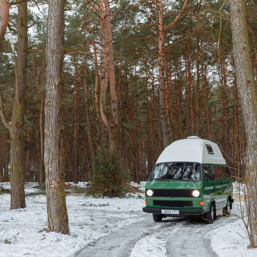 Ancien camping-car enneigé en forêt hivernale