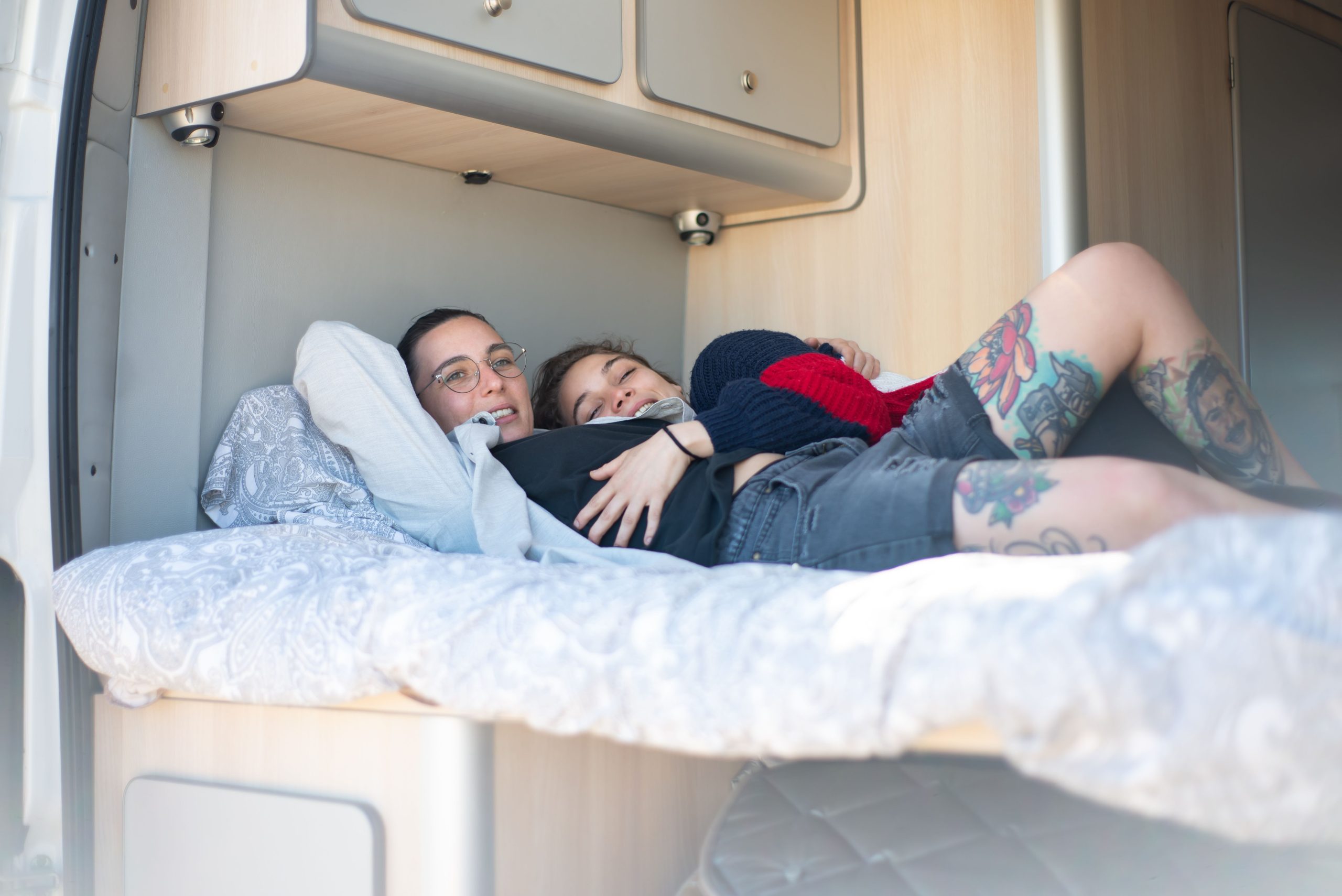 Couple souriant enlacé intérieur camping-car cozy