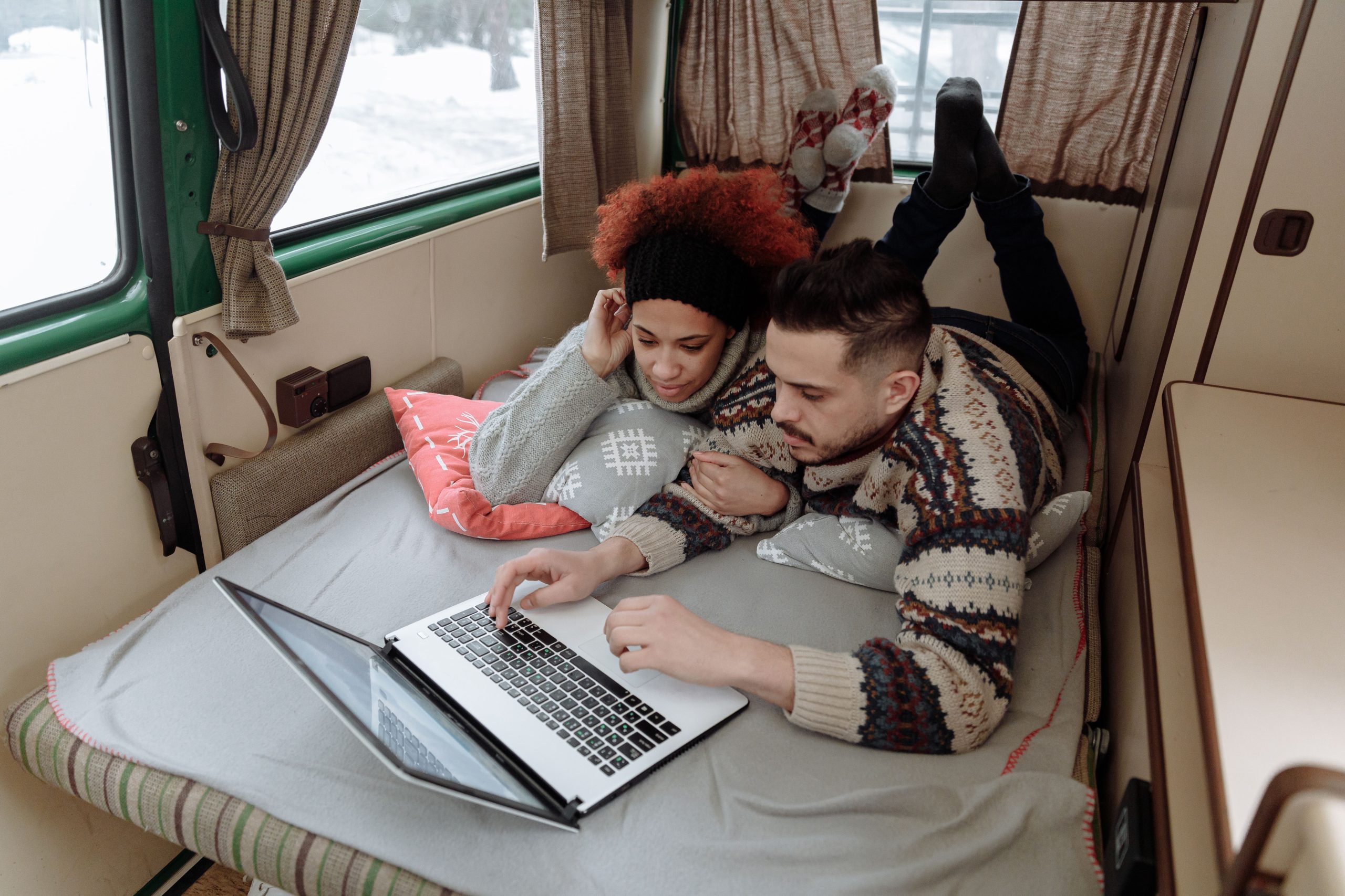 Couple relaxant dans camping-car avec ordinateur