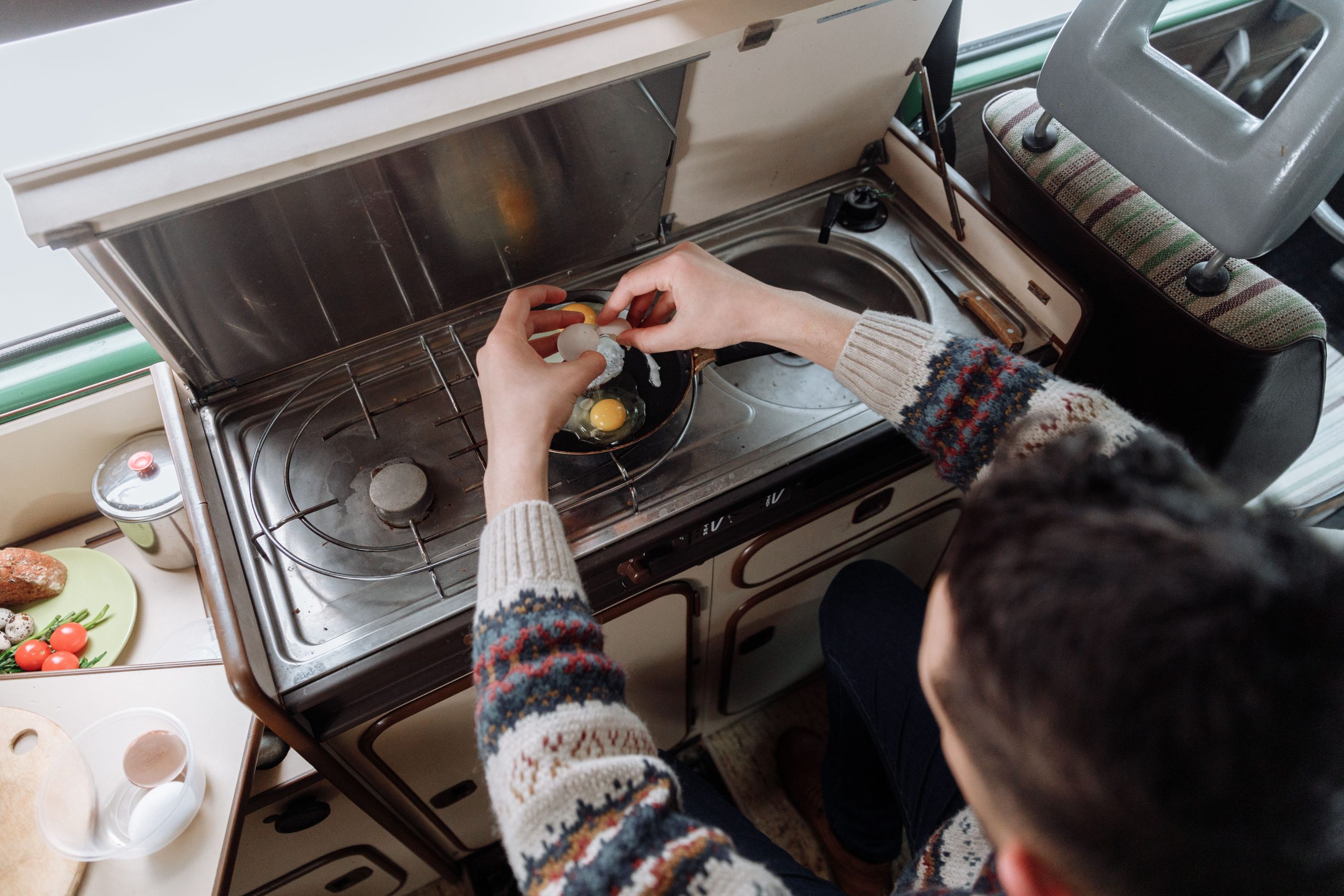 Préparation culinaire dans un van aménagé compact