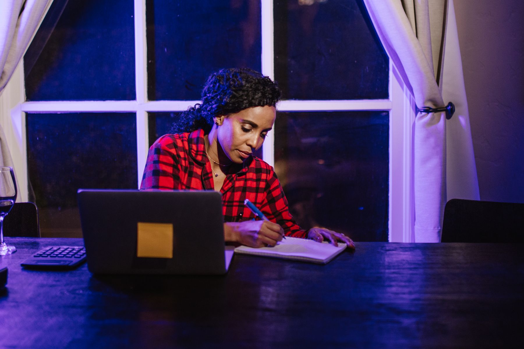 Femme travaillant sur ordinateur portable à un bureau près d'une fenêtre
