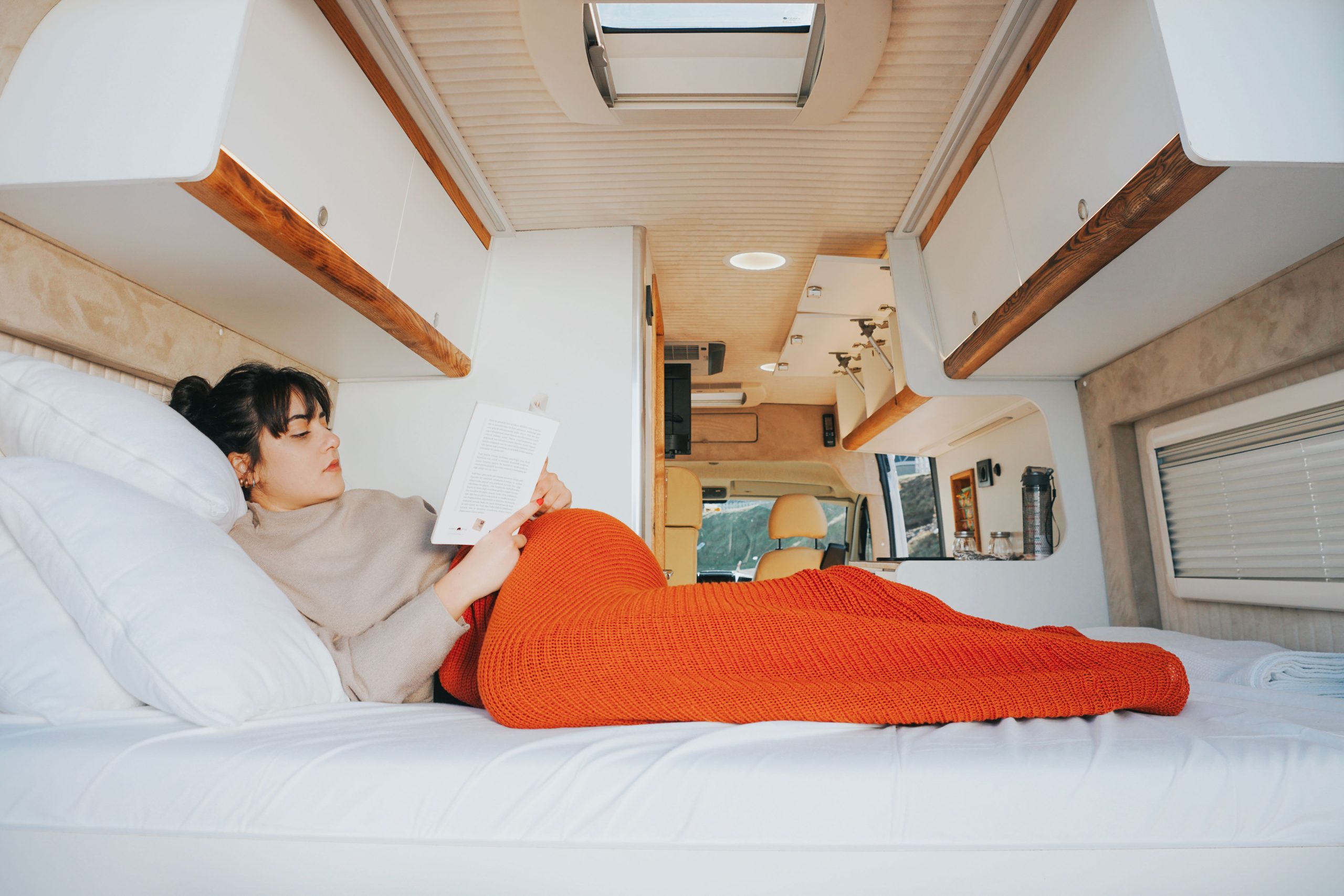 Femme lisant confortablement dans son van