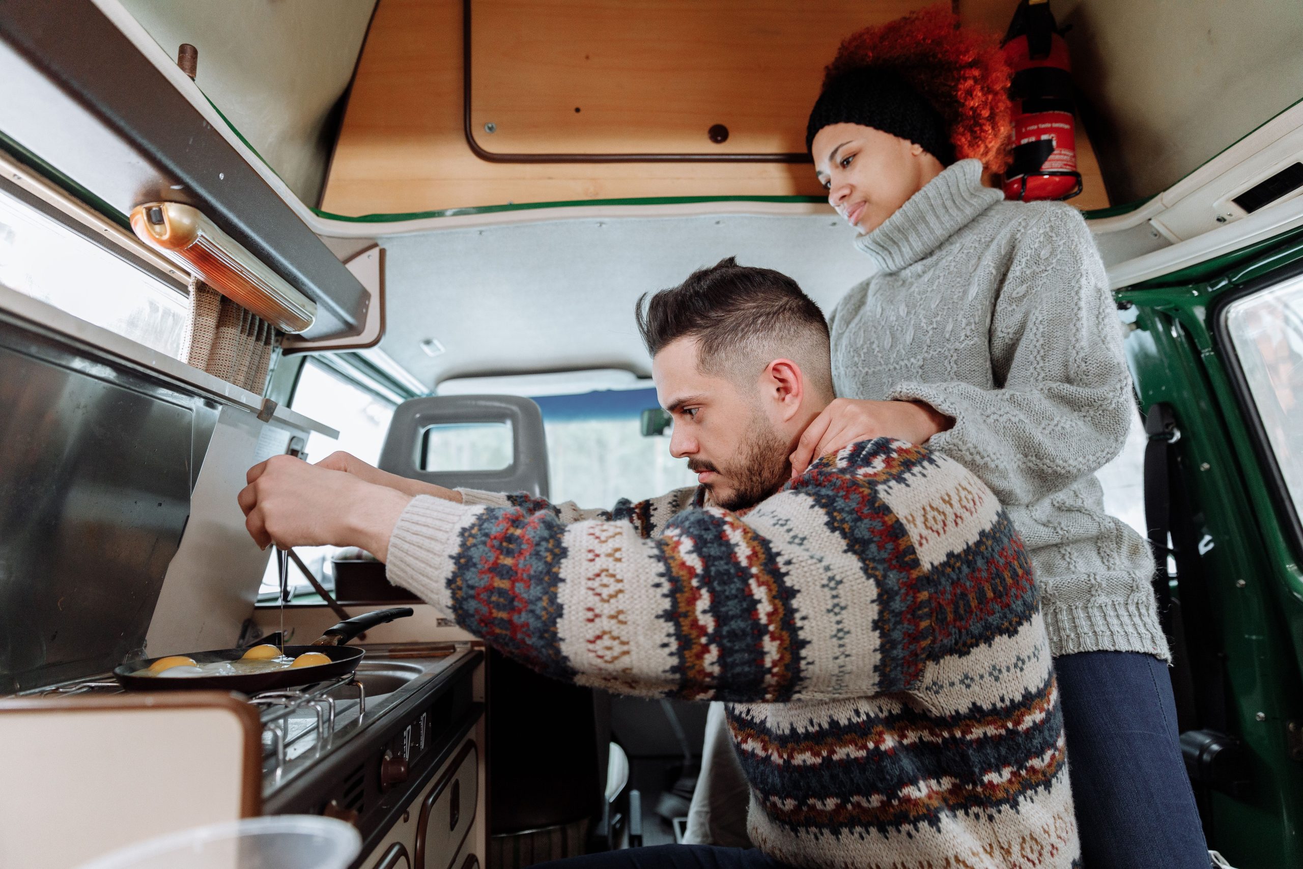 Couple préparant le petit déjeuner dans un van aménagé