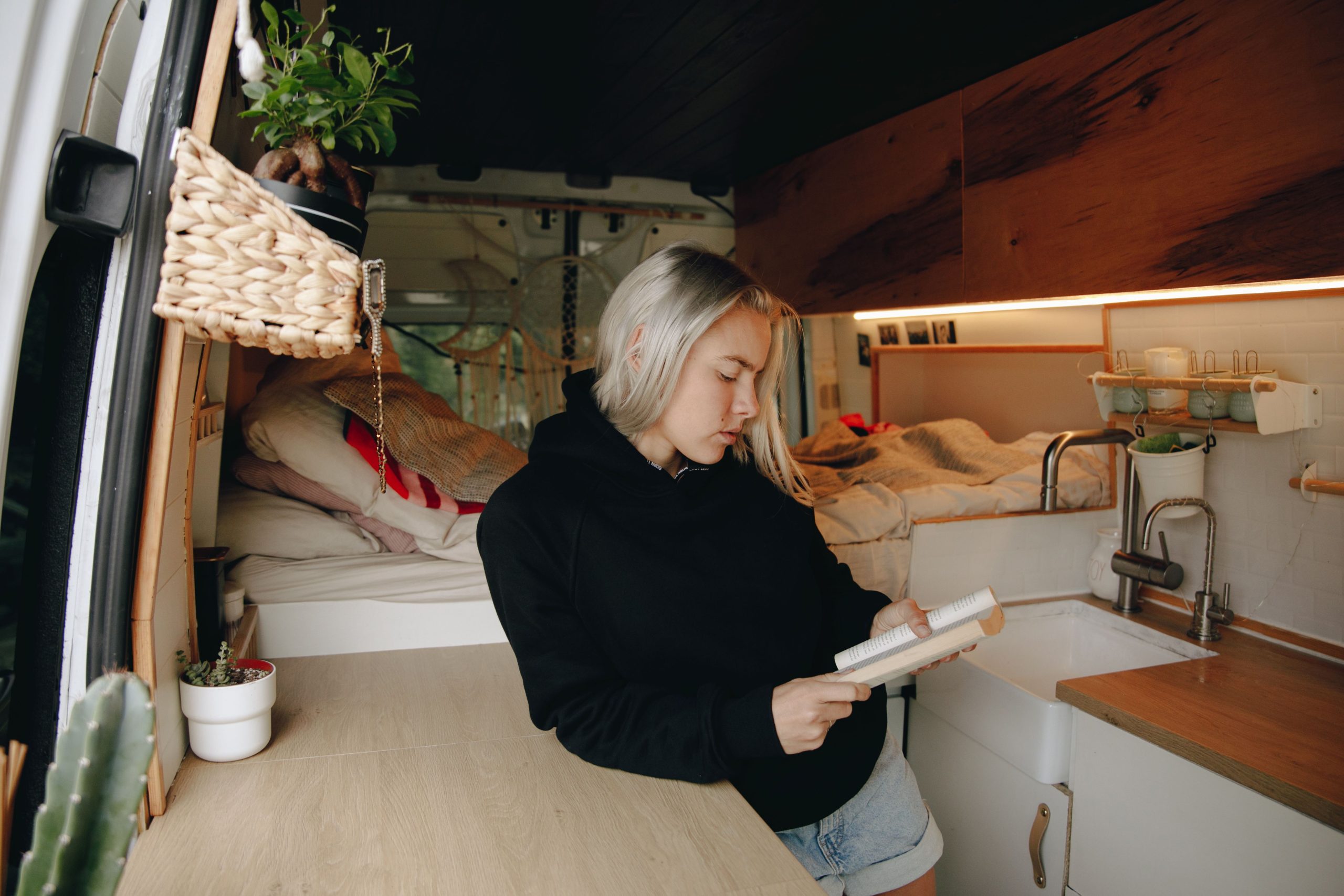 Femme relaxant à l'intérieur d'un van aménagé